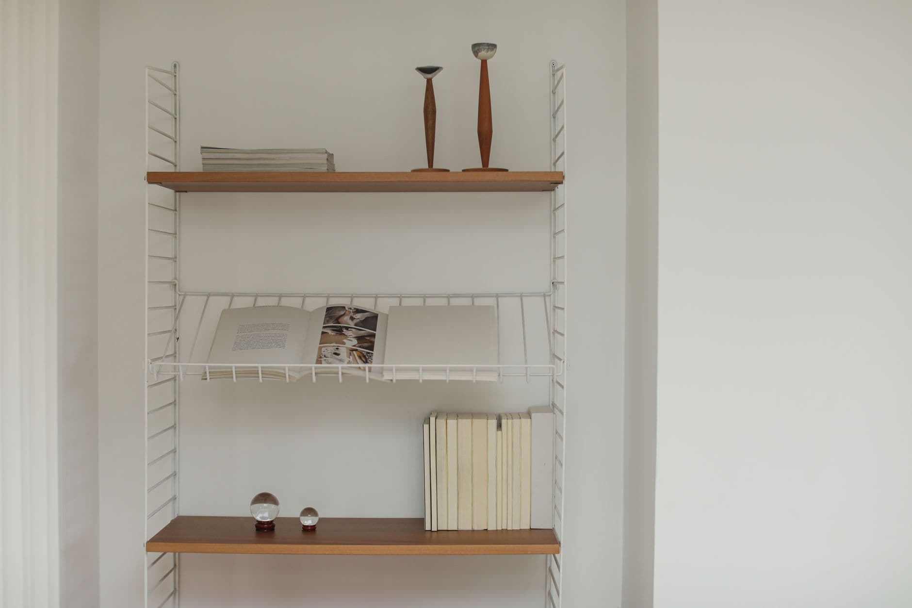 A minimalist shelf holding a short row of books beside a gap
