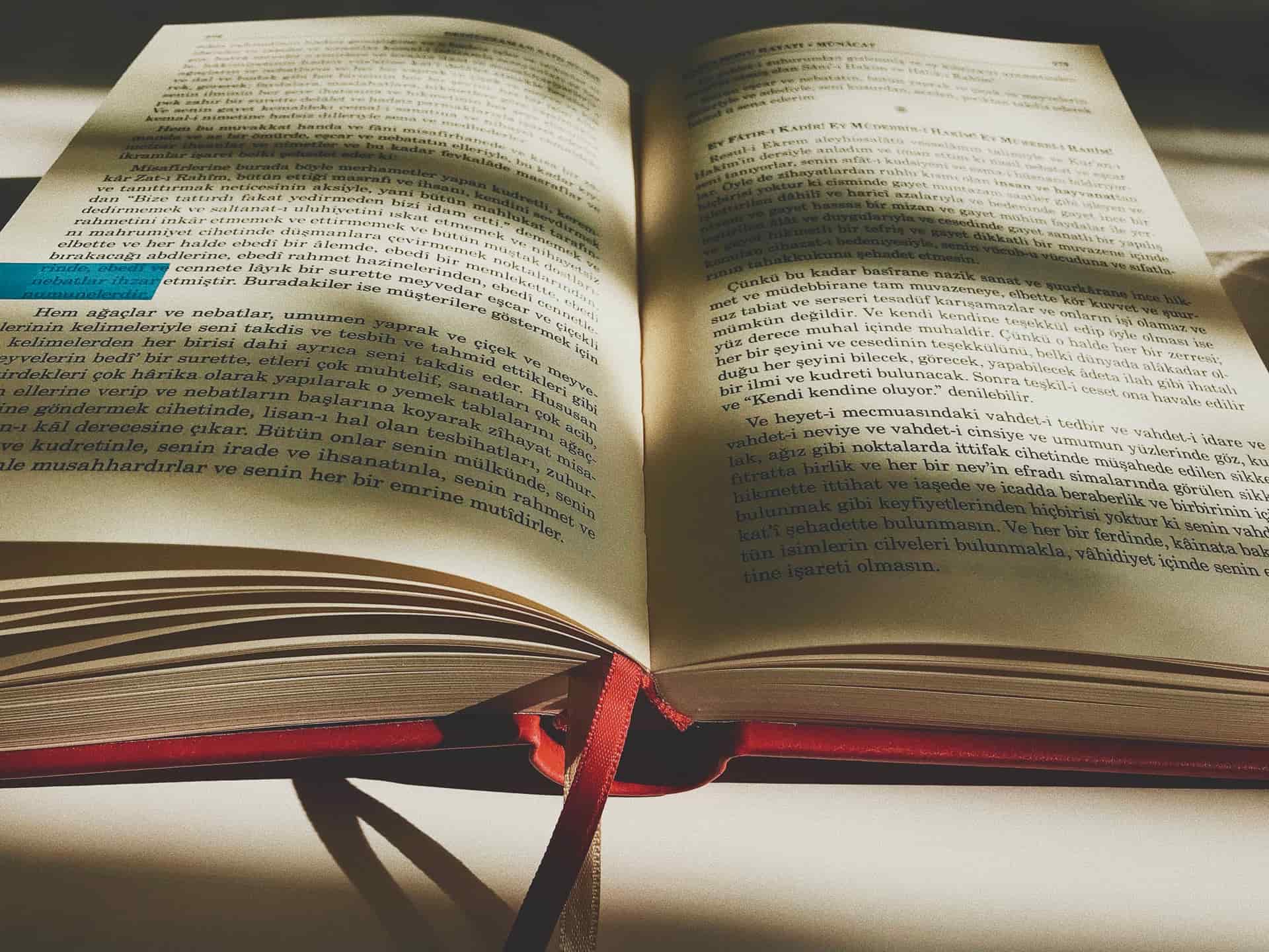A ribbon bookmark laid across the pages of an open book