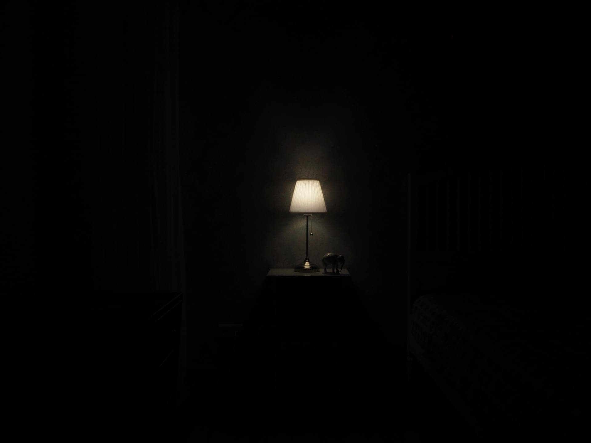 A warm bedside lamp glowing in a dark room