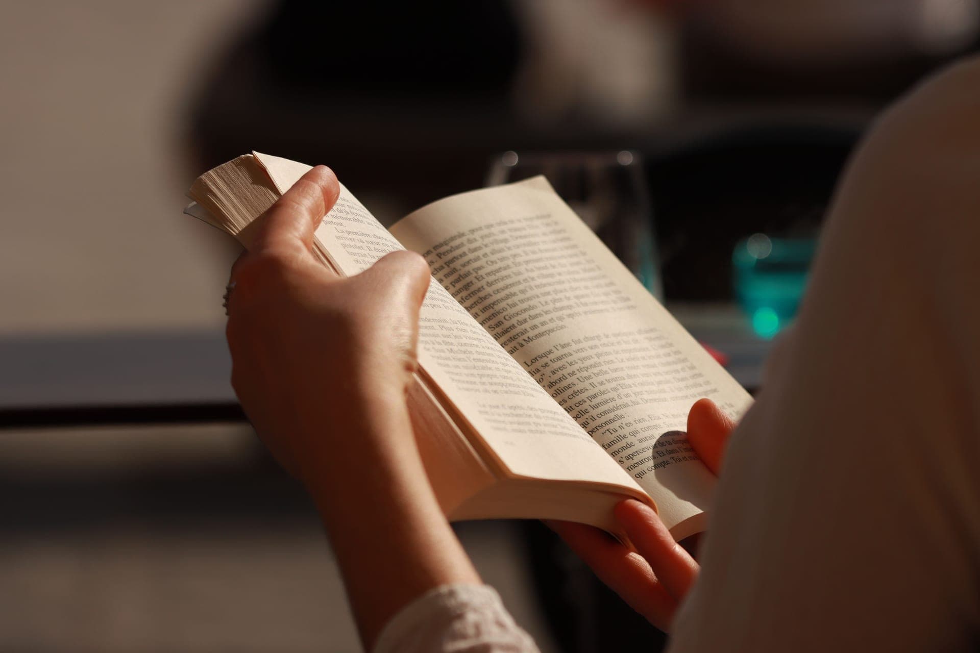 Hands holding an open paperback book