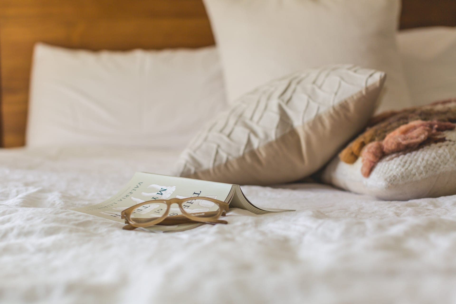 Pillows arranged on a bed beside an open book