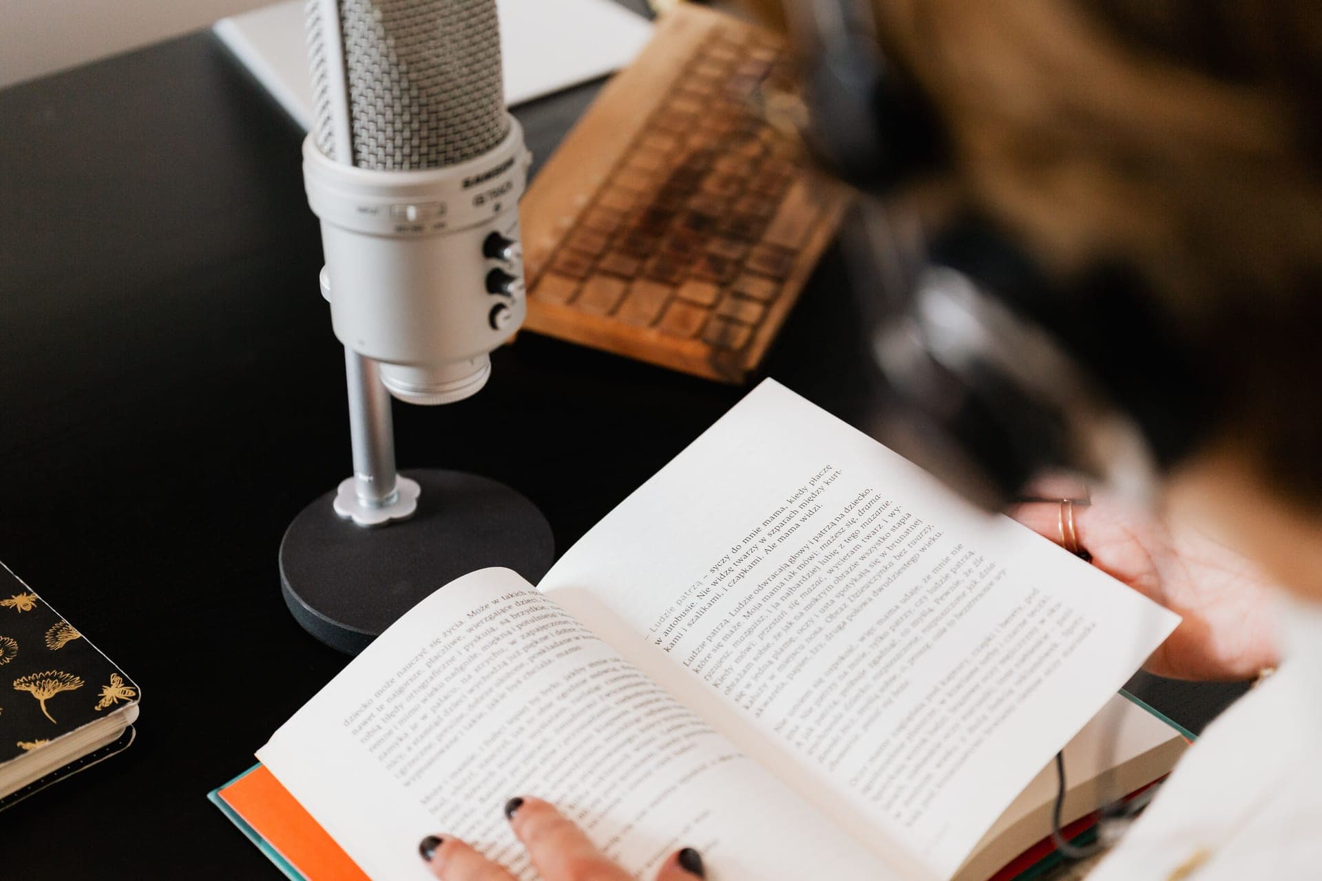 A person reading at a desk with a book propped in front of them
