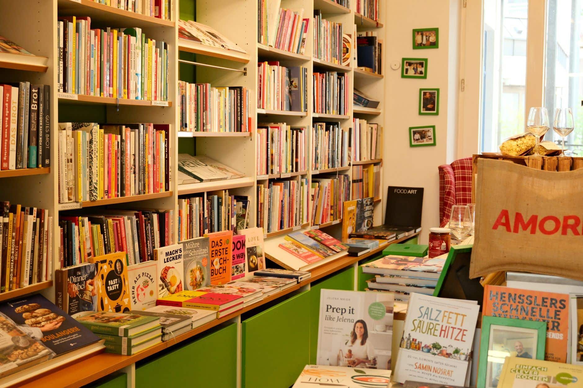 Colorful cookbooks standing on open wooden shelves