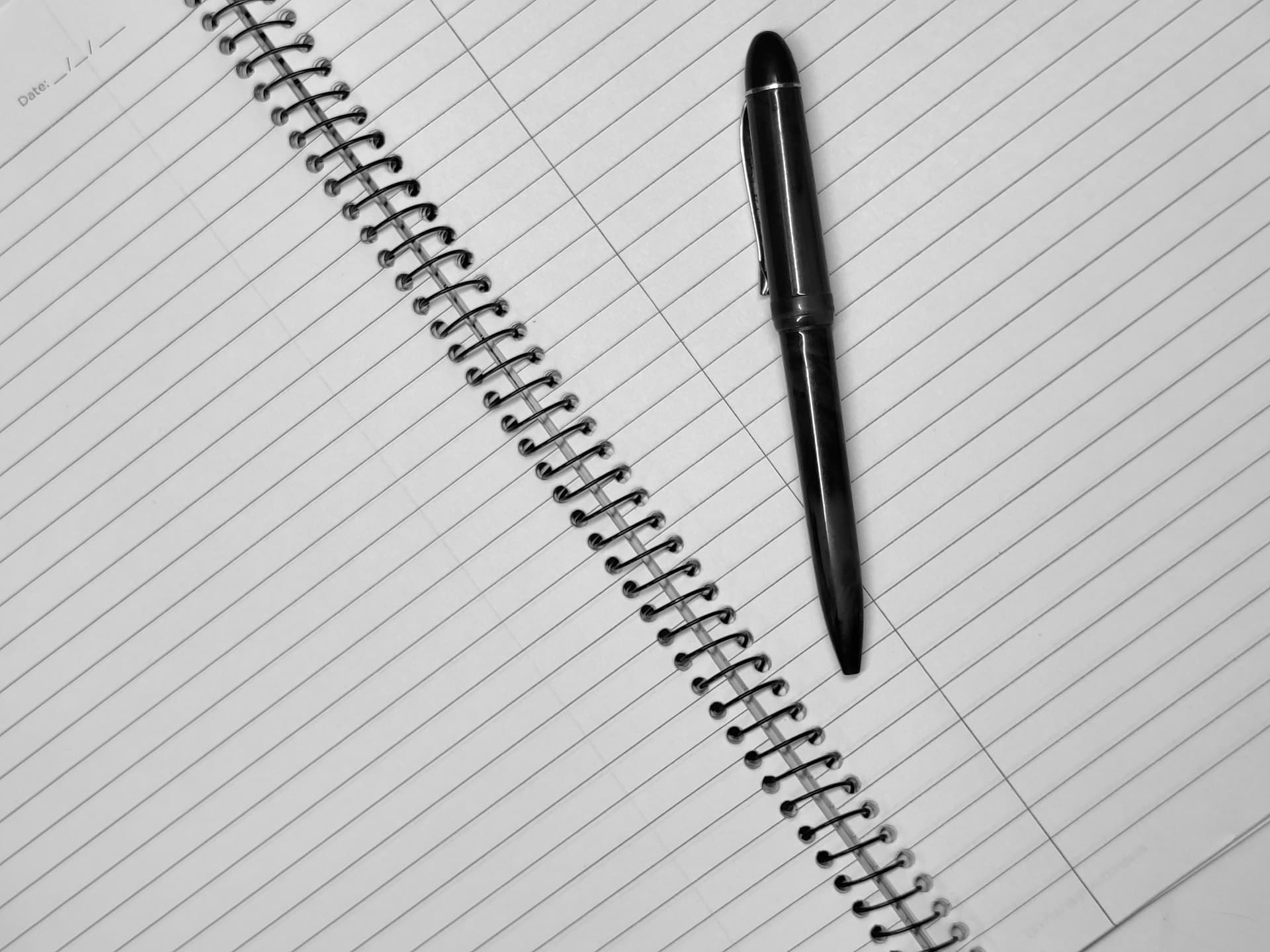 A blank notebook page with a pen resting on it