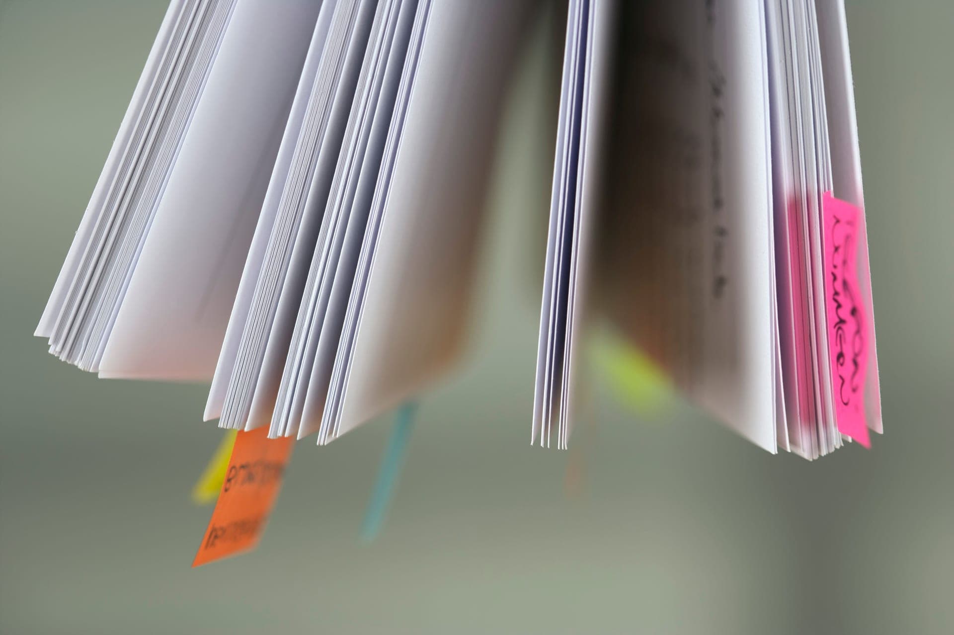 An open book with colorful sticky tabs marking several pages