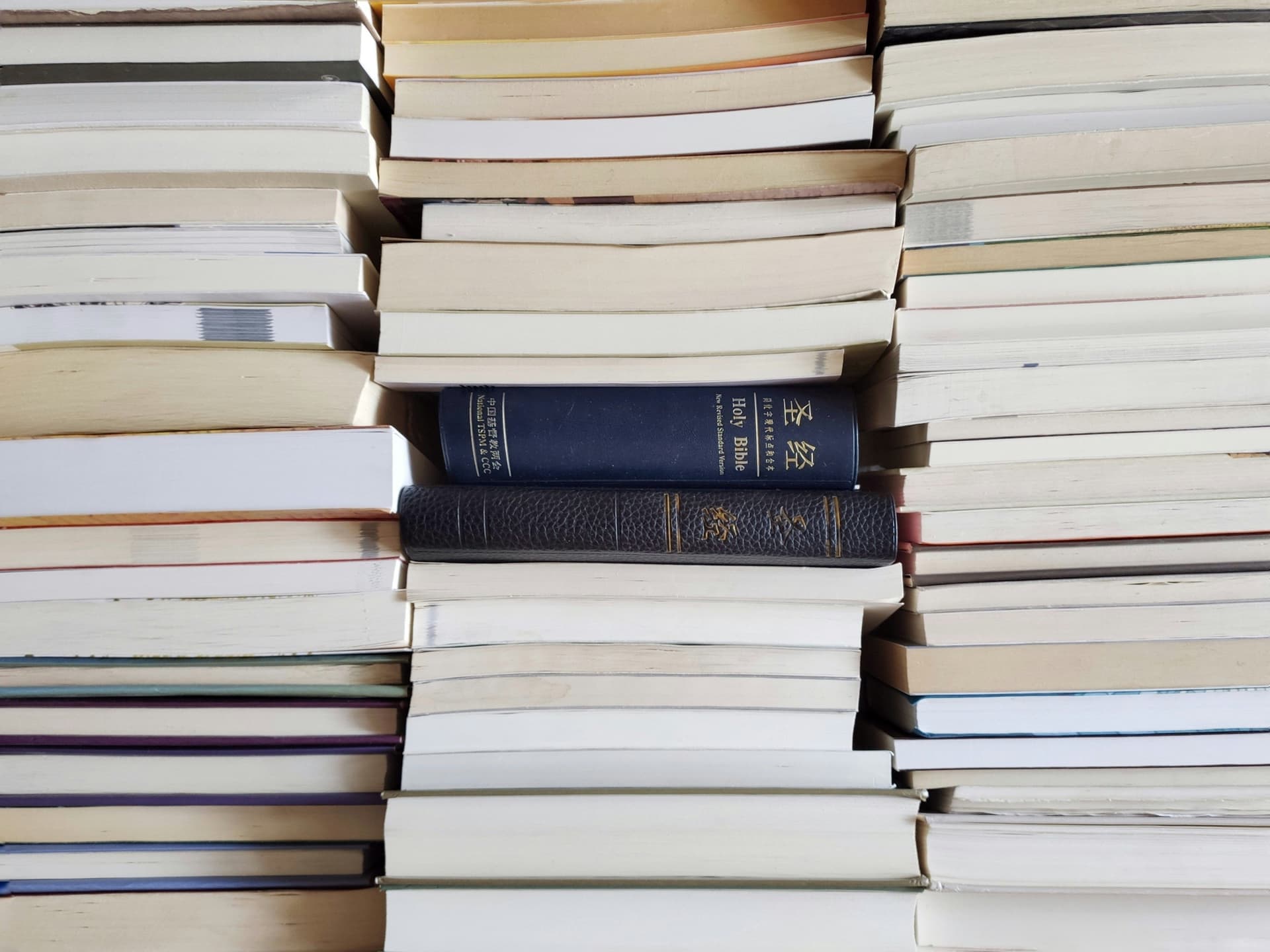 A stack of thick hardcover books on a table