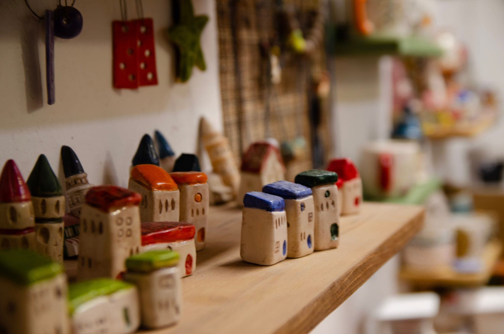 A miniature model house displayed on a wooden shelf
