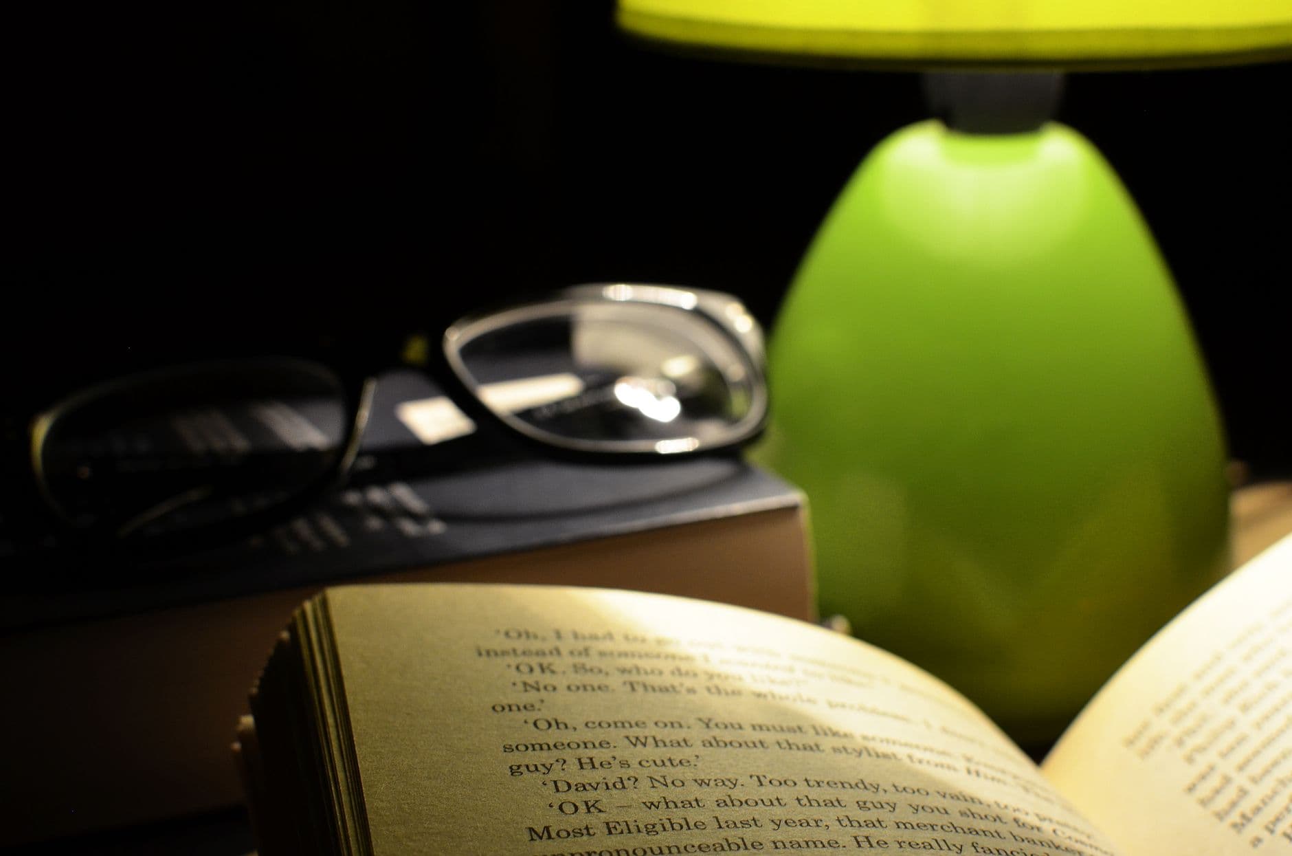 A small reading light clipped to the cover of an open book